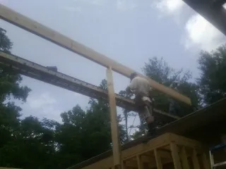 Carpenter setting a ridge beam over a new addition frame — Ice Dam Removal by Roofing Brothers in Winnetka
