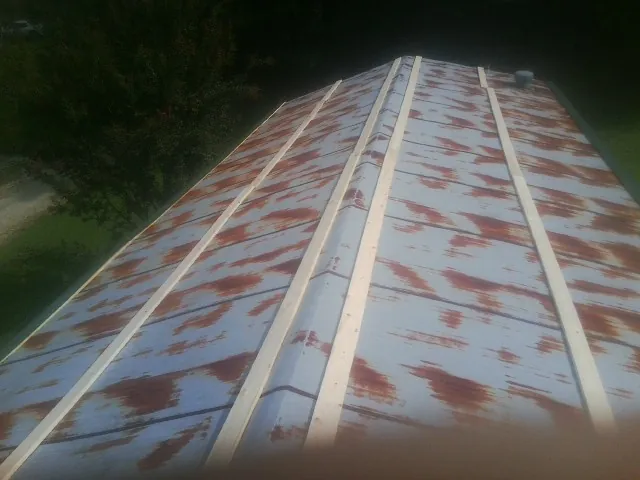 Rusted metal roof panels with new wood purlins before replacement — Storm Damage Roof Repair in Winnetka by Roofing Brothers